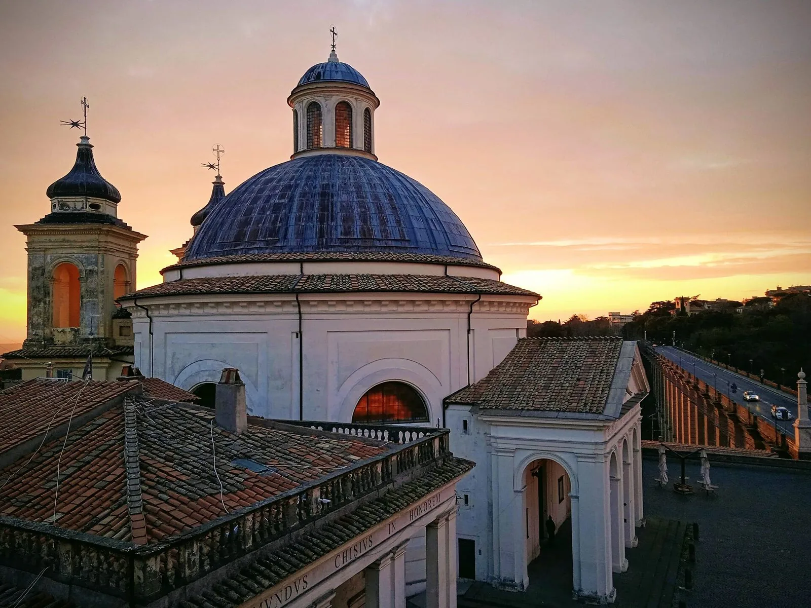 La cupola della collegiata di Santa Maria Assunta ad Ariccia al tramonto, con il ponte monumentale sulla destra